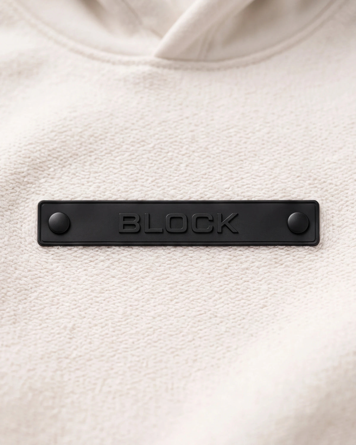 Banner 01 — Black module mounted on cream platform hoodie chest anchor