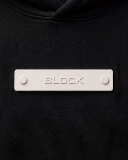 Banner 01 — Cream module mounted on black platform hoodie chest anchor