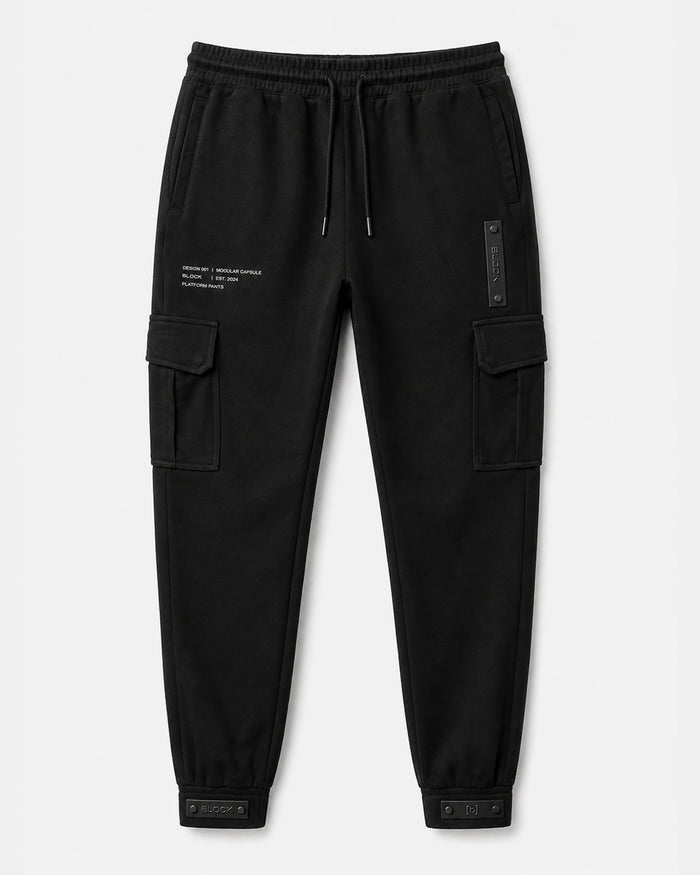 Black — Cargo Pant 01 — laid flat, bellowed thigh pockets, hip module, cuff tabs